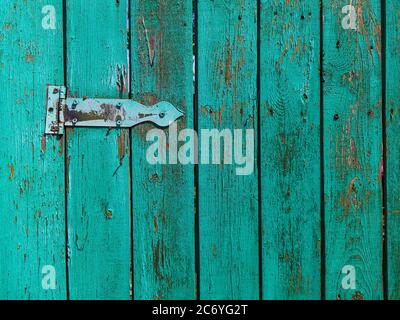 Old rusty door hinge on a wooden fence door. Stock Photo