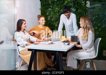 Smiling black manager coach speaking at caucasian corporate meeting, african coach, leader talking to office workers at training teaching employees ex Stock Photo