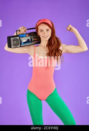 female model with long red hair and athletic body shape, posing for fitness  club advertisment, wears comfortable colorful aerobics outfit, smiles joyf  Stock Photo - Alamy