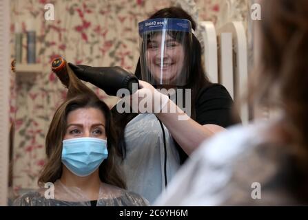 Salon manager Gemma Inglis works on the hair of Shireen Inglis at The Lunatic Fringe in Glasgow as they demonstrate some of the changes put in place to help protect against coronavirus. Hairdressers across Scotland are preparing to reopen to customers on Wednesday as lockdown measure are eased. Stock Photo