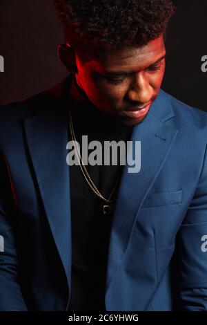 Portrait of handsome self-confident well-groomed imposing man in blazer suit, corporative manager or leader of IT company posing isolated over dark re Stock Photo
