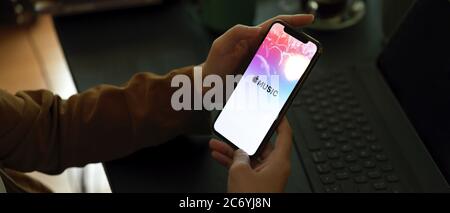 CHIANG MAI, THAILAND - JULY 9, 2020 : female holding iPhone with Apple Music screen. Apple Music is music streaming service Stock Photo