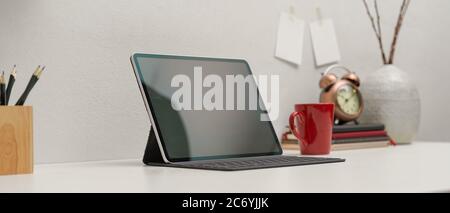 Cropped shot of digital tablet with keyboard on modern worktable with stationery and decorations Stock Photo