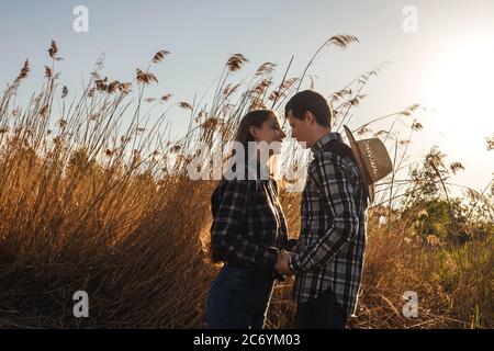 A couple in love in the field on beautiful sky background. Profile