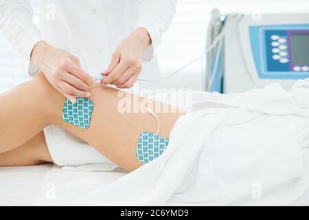 Myostimulation on the legs and hips of a slim fit woman in beauty salon. Non surgical body sculpting. anti-cellulite and body slimming therapy in cosm Stock Photo