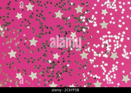 Silver shiny stars on a magenta background. Festive backdrop for