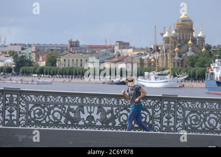 St. Petersburg, Russia - July 12, 2020: Girl jogging on the Blagoveshchensky bridge across Neva river Stock Photo