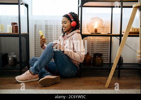 Woman sitting on the floor and listen to music Stock Photo