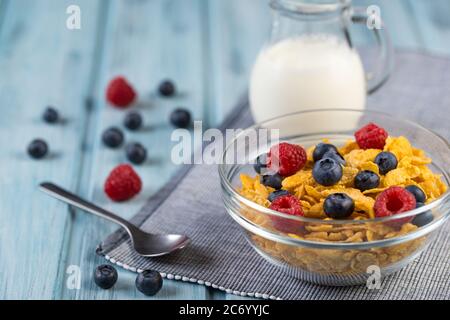 Healthy breakfast corn cereal with fresh ripe berries and milk jug Stock Photo