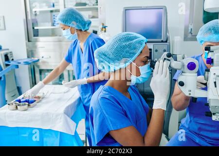 Surgeons performing laser eye vision correction surgery in ophthalmology clinic Stock Photo