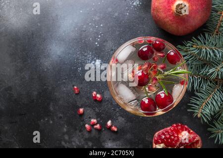 Pomegranate Christmas cocktail with rosemary, club soda on black. Close up. View from above. Stock Photo