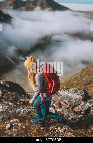 Woman hiking in mountains with red backpack travel trail running activity summer vacations healthy lifestyle outdoor adventure solo trekking in Norway Stock Photo