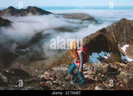 Woman adventurer hiking in mountains with backpack travel outdoor trekking alone summer vacations activity healthy lifestyle trail in Norway Stock Photo