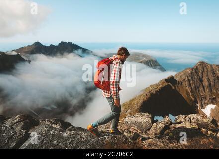 Man traveler hiking with backpack above clouds travel outdoor in mountains adventure vacation active healthy lifestyle extreme sports summer activity Stock Photo