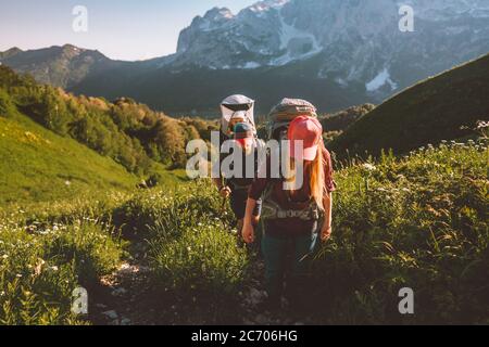 Family hiking with baby travel summer vacation couple man and woman backpacking outdoor active healthy lifestyle adventure tour in mountains Stock Photo