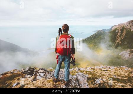 Man traveler hiking with backpack and photo camera in mountains travel influencer blogger hobby healthy lifestyle adventure summer tour in Norway Stock Photo