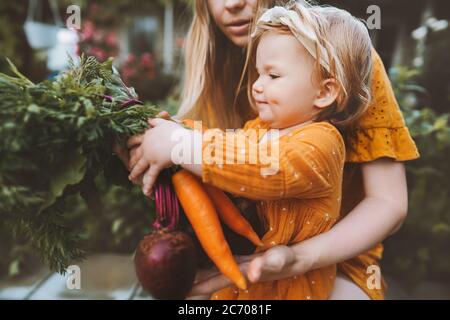 Family mother and child girl with organic vegetables healthy eating lifestyle vegan food homegrown carrot and beetroot local farming grocery shopping