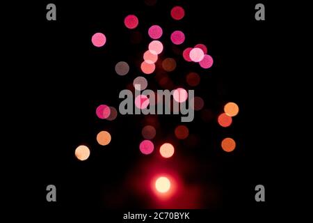 Firework of blurred red pink lights on a black background. Valentines day concept. New year concept. Copy space. Stock Photo