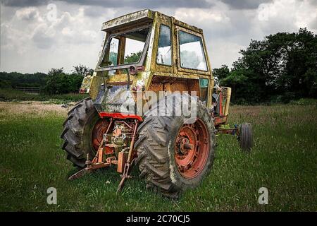decaying in need or repair american case 970 tractor in field with moody sky Stock Photo