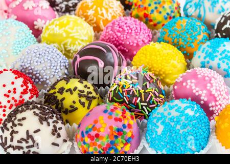Different colorful cake balls with decorative sprinkles in paper form Stock Photo