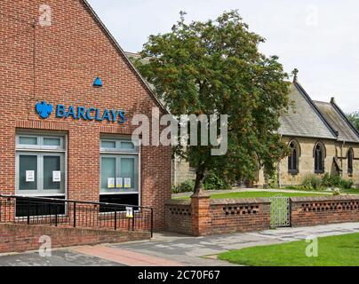 Barclays bank and St Mary's Church, Haxby, near York, North Yorkshire, England UK Stock Photo