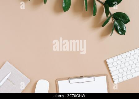 The apartment lay in the workplace of the home office. Office supplies: keyboard, mouse, Notepad, pen, tablet with a clean sheet of paper and a branch Stock Photo