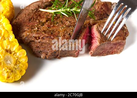 Medium rear beef steak. White plate with Piece of beef steak on fork. Stock Photo