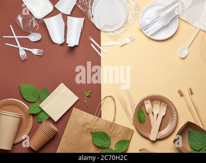 non-degradable plastic waste from disposable tableware and a set of dishes from environmental recycled materials on a brown background. The concept of Stock Photo