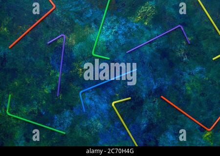 Marine life and plastic tubes. Art concept. Symbol plastic trash in the sea. Flat lay on blue ocean background. Stock Photo