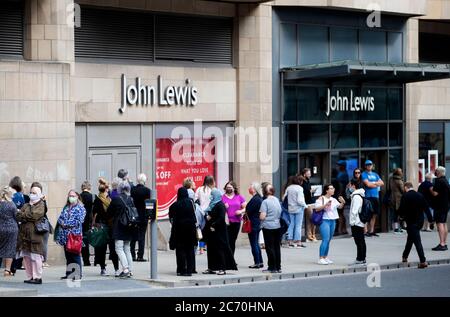 People queue outside the John Lewis department store in Edinburgh which re-opened its doors today as Scotland prepares for the lifting of further coronavirus lockdown restrictions. Stock Photo