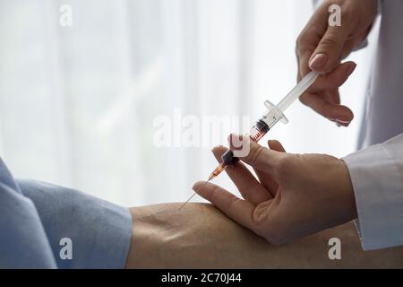 Close up syringe containing blood from covid 19 patient. Coronavirus disease 2019 testing process in a hospital. Stock Photo