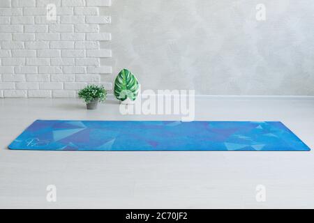 Light yoga room with mat and white brick wall. Stock Photo