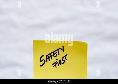 Safety first handwriting text close up isolated on yellow paper with copy space. Stock Photo