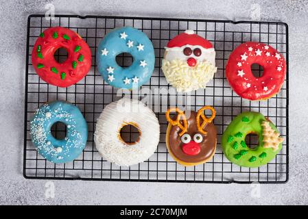 Set of Christmas donuts on baking rack on gray stone background. Christmas and New Year celebration concept. Top view. Stock Photo