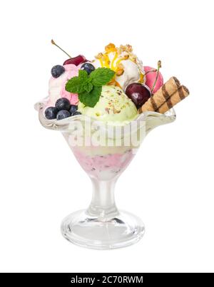 Different ice cream balls with fresh berries and wafer sticks in glass vase isolated on white background. Stock Photo