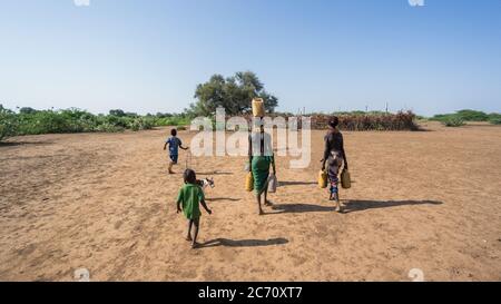 Omorate, Ethiopia - September 2017: Unidentified woman from Dassanech tribe carrying water to her village, Ethiopia Stock Photo