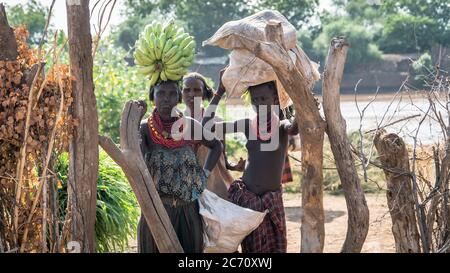 Omorate, Ethiopia - September 2017: Unidentified girls from Dassanech tribe carrying fruit, Ethiopia Stock Photo