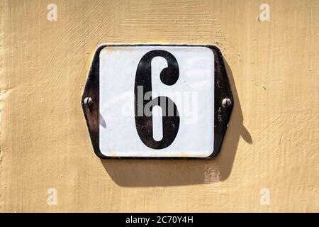 Number 6 in white on a black metal plate Stock Photo