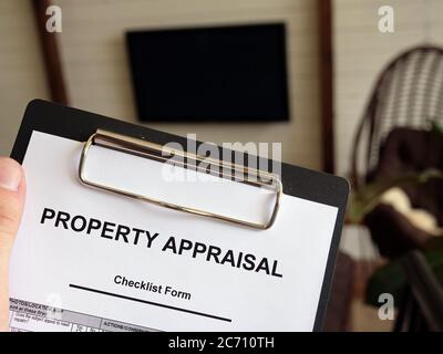 Man shows Property appraisal checklist form. How much is your home worth. Stock Photo