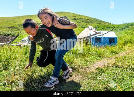 Ili, China's Xinjiang Uygur Autonomous Region. 2nd July, 2020. Children play at the summer meadow in Tekes County, northwest China's Xinjiang Uygur Autonomous Region, July 2, 2020. Credit: Wang Fei/Xinhua/Alamy Live News Stock Photo