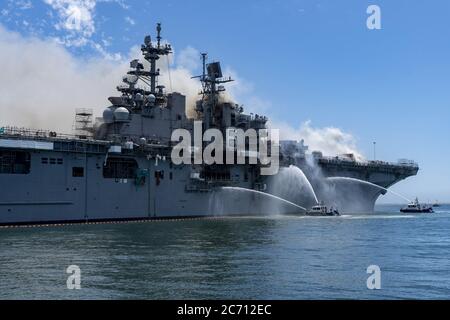San Diego, United States. 13th July, 2020. Port of San Diego Harbor Police Department boats combat a fire onboard USS Bonhomme Richard (LHD 6) at Naval Base San Diego on July 12, 2020. On the morning of July 12, a fire was called away aboard the ship while it was moored pier side at Naval Base San Diego. Local, base, and shipboard firefighters responded to the fire. USS Bonhomme Richard is going through a maintenance availability, which began in 2018. Photo by MC3 Christina Ross/U.S. Navy/UPI Credit: UPI/Alamy Live News Stock Photo