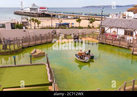 Bournemouth, Dorset UK. 13th July 2020.  Visitors return to visitor attractions in Bournemouth with the easing of Coronaviris Covid-19 pandemic outbreak restrictions - having fun at Smugglers Cove Adventure Golf in Pier Approach.  Credit: Carolyn Jenkins/Alamy Live News Stock Photo