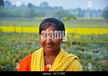An Indian teenager girl smiling in a rural village field, selective focusing Stock Photo