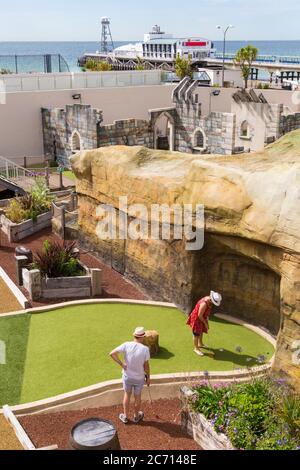 Bournemouth, Dorset UK. 13th July 2020.  Visitors return to visitor attractions in Bournemouth with the easing of Coronaviris Covid-19 pandemic outbreak restrictions - having fun at Smugglers Cove Adventure Golf in Pier Approach.  Credit: Carolyn Jenkins/Alamy Live News Stock Photo