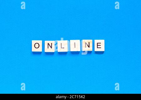 Word Online made with wooden letterpress cubes on blue background. ONLINE written on wood cubes. Conceptual. Expanding business online. Expanding busi Stock Photo