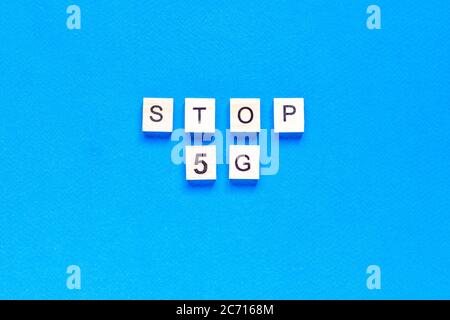 stop 5 g. 5 G. Five G's, written in wooden letters on a blue background. Flat layout. Wireless network. New technology. top view. Stock Photo