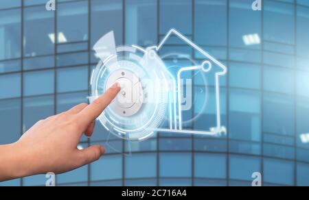 Woman presses a button on the control panel of a smart home. Concept Stock Photo