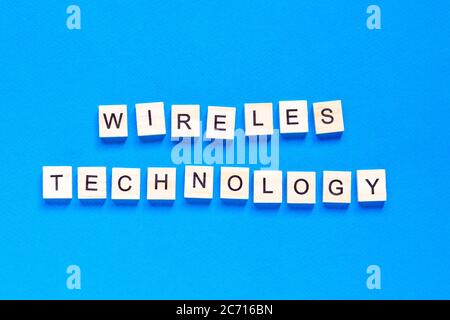 wireless technology lettering in wooden letters. The words wireless technology, spelt with wooden letter tiles over a white background. Stock Photo