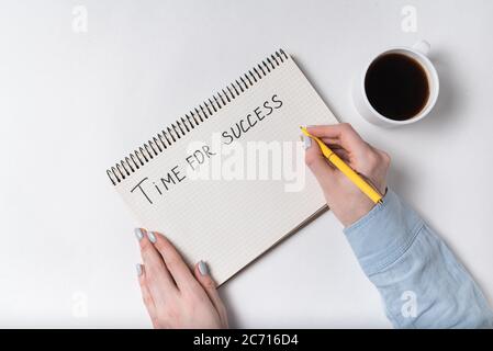 Notepad with words TIME FOR SUCCESS. Female hands with Cup of coffee and copybook on white background Stock Photo