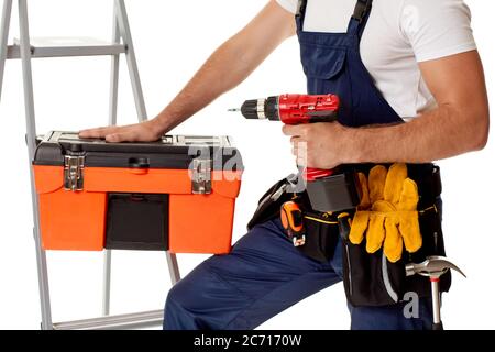 repairman holding cordless screwdriver and tool box. handyman with working tools on belt Stock Photo